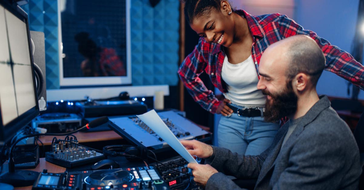 Male and female Recording Engineers in studio