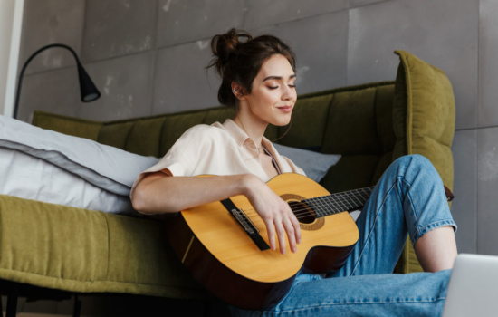 Woman playing guitar in her room
