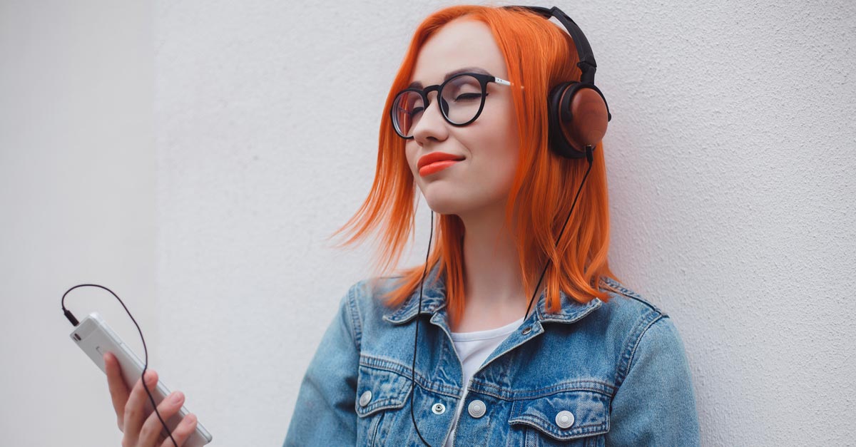 Red-haired woman listening to music on her phone